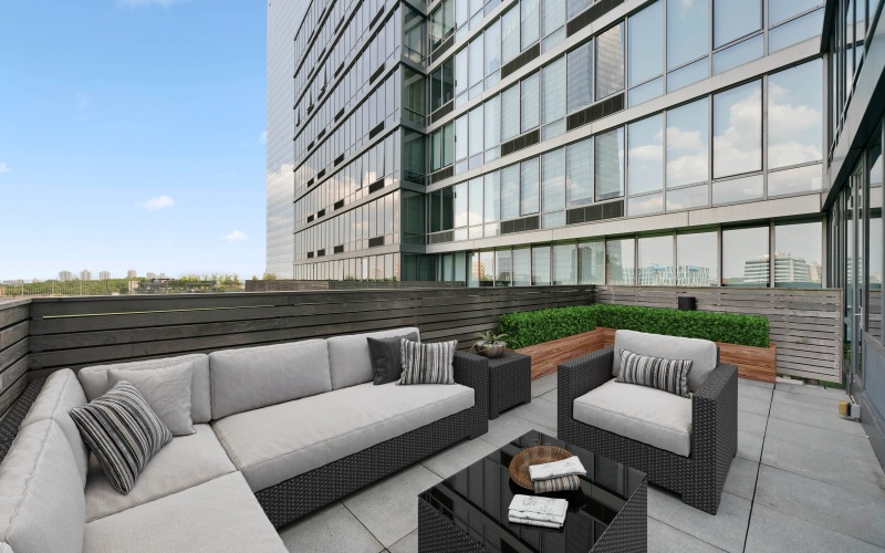 Outdoor apartment terrace with sofa, chair, and coffee table