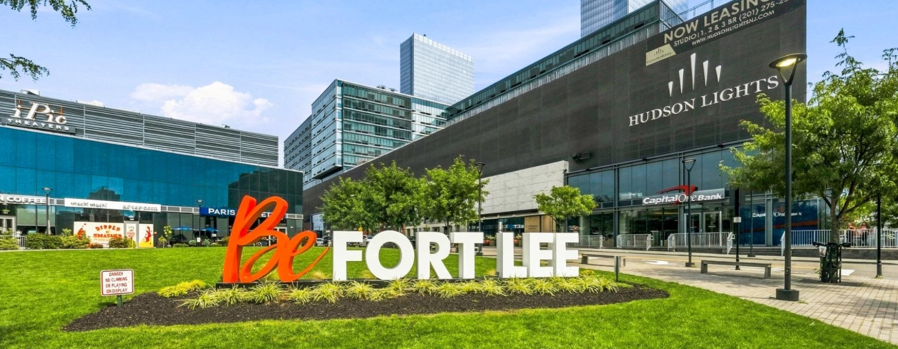 A Be Fort Lee sign with Hudson Light building in the background