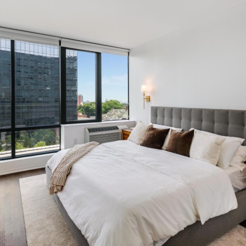 a bedroom with a bed and a large window
