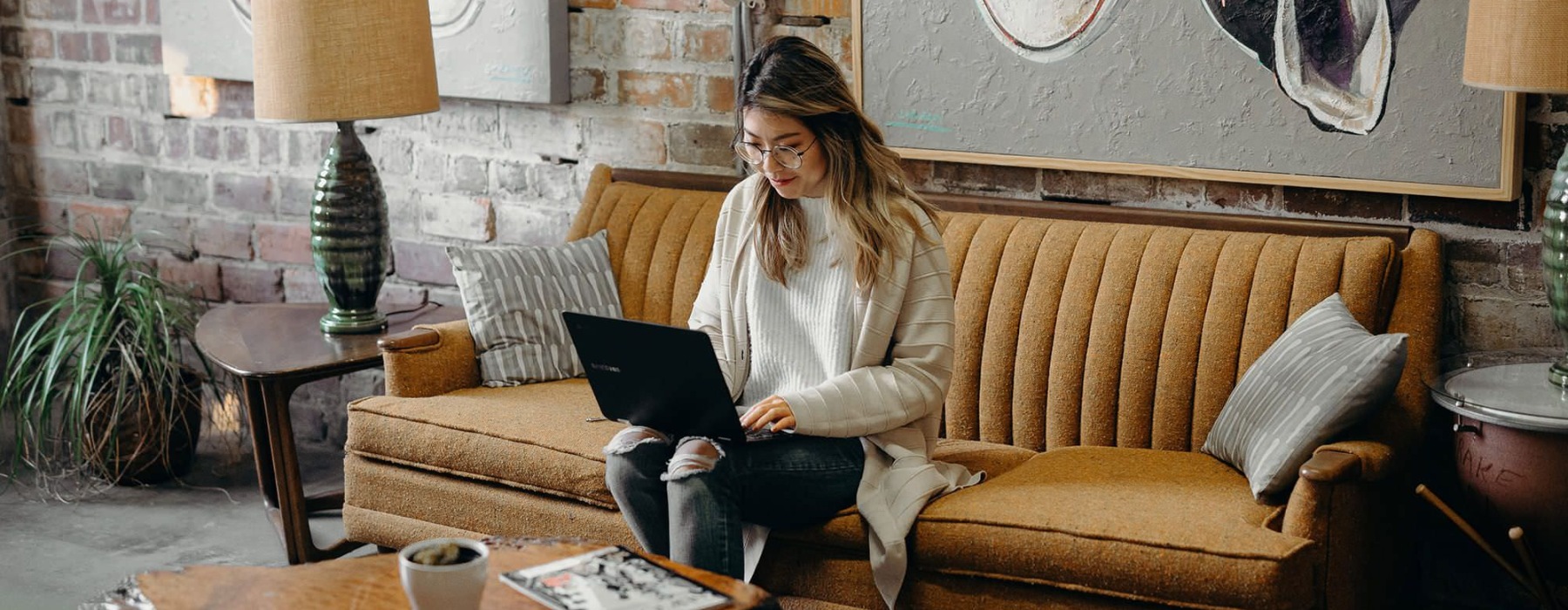 woman sitting on couch using a laptop